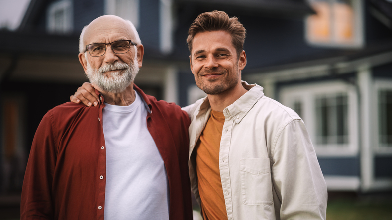 Father and son outside a house with arms over shoulders, equity release to help with property ladder