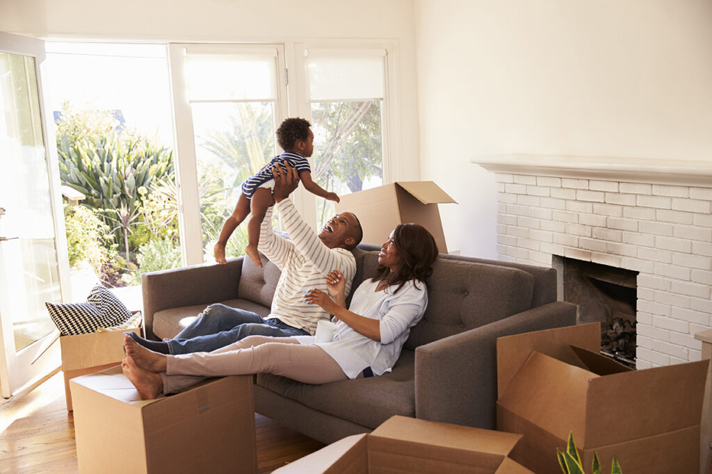 Parents Take A Break On Sofa With Son On Moving Day